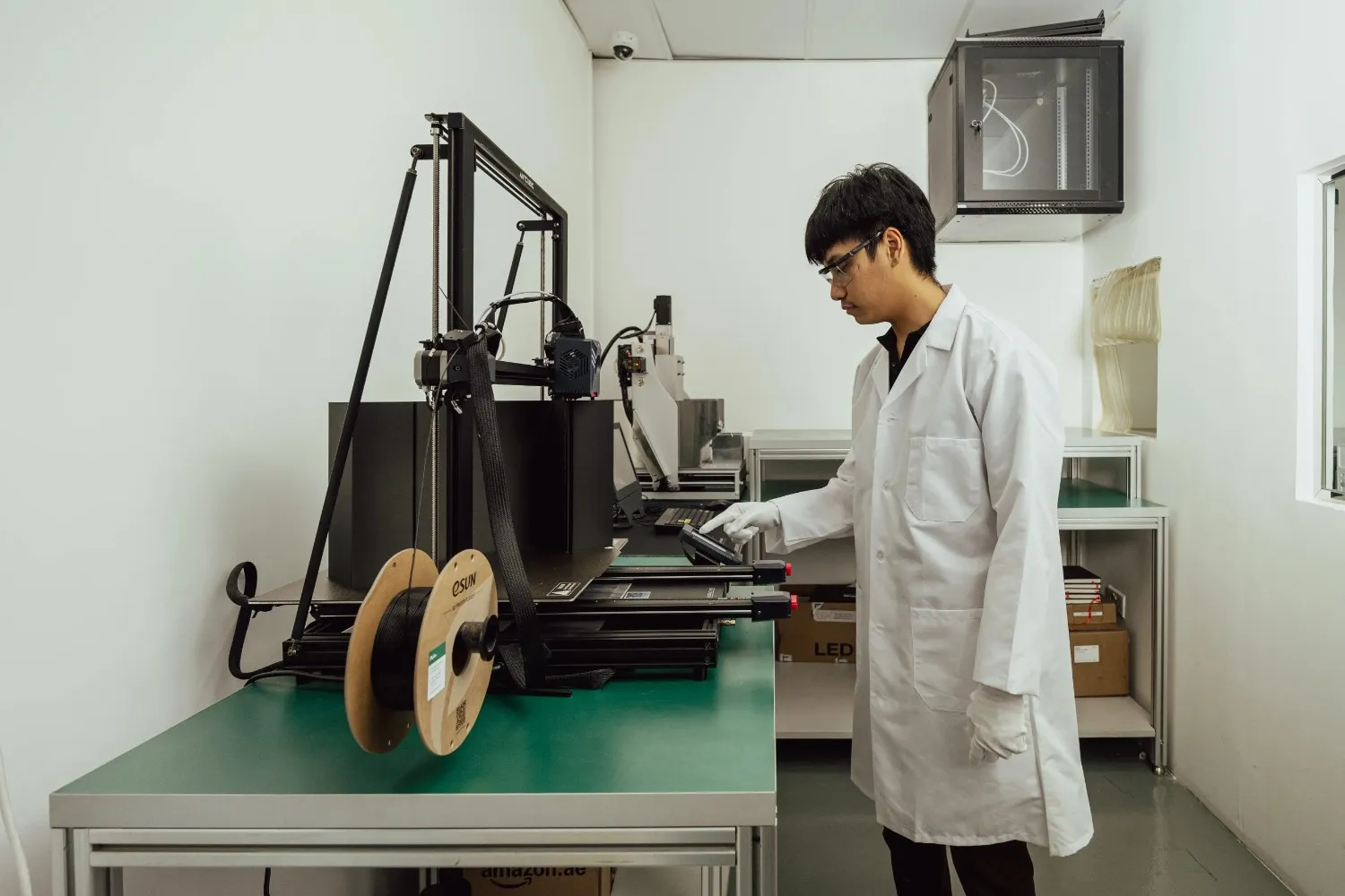 Engineer operating 3D printing equipment during LED lighting prototype testing at LEDFlex